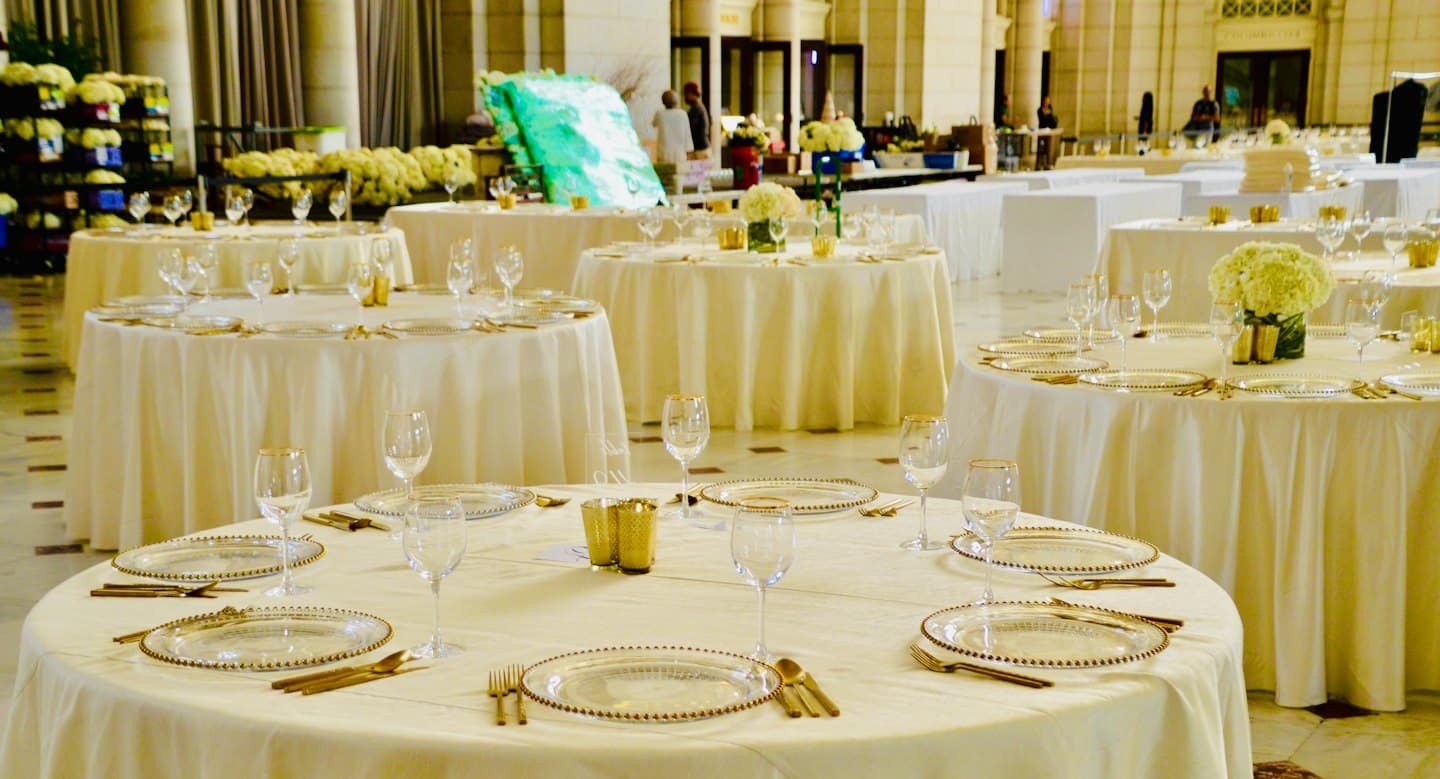 Elegantly set round tables in a grand event hall.